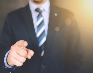 A man in suit pointing his finger onwards